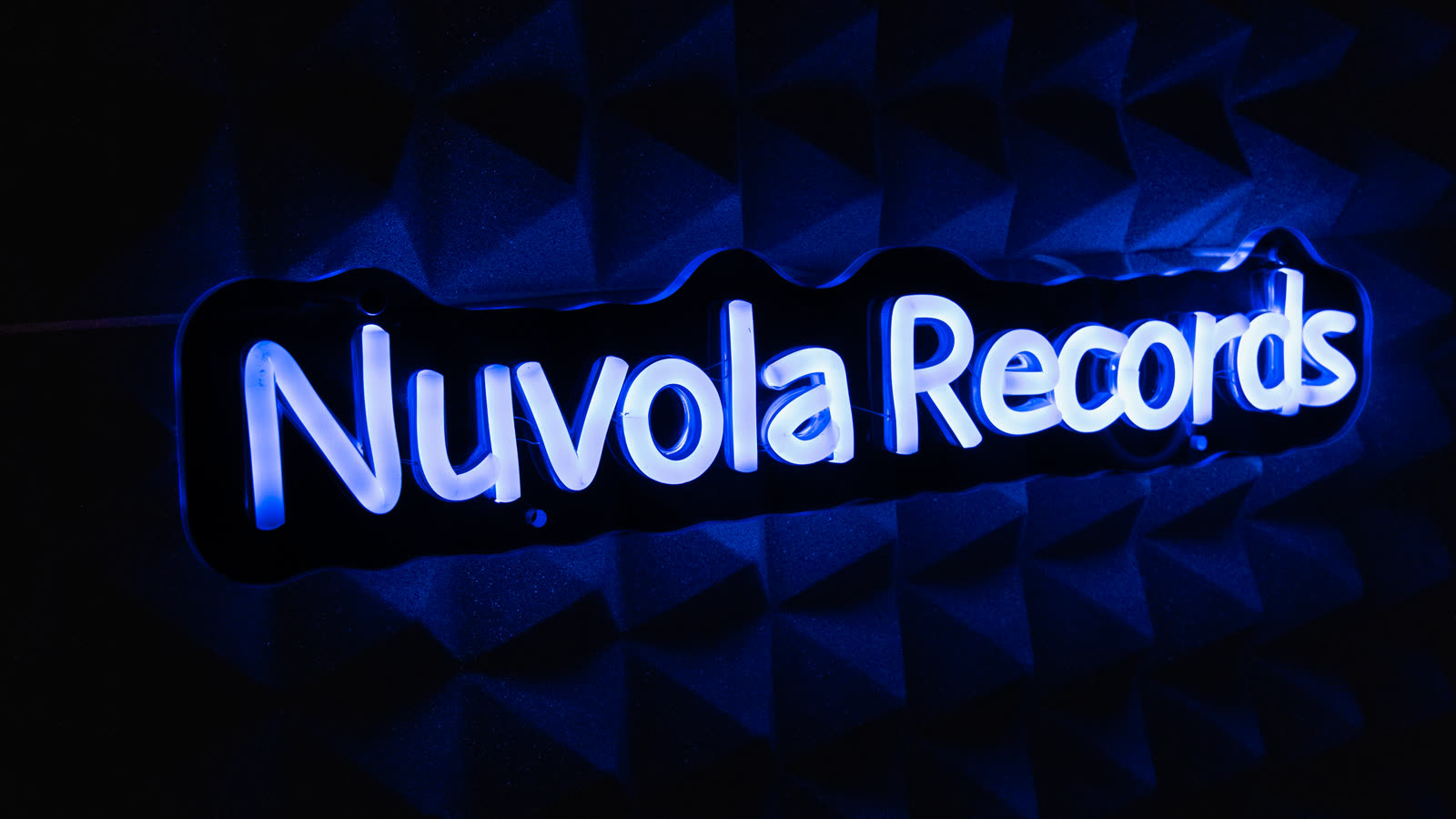 L'insegna al neon «Nuvola Records» accesa sulla parete fonoassorbente dello studio